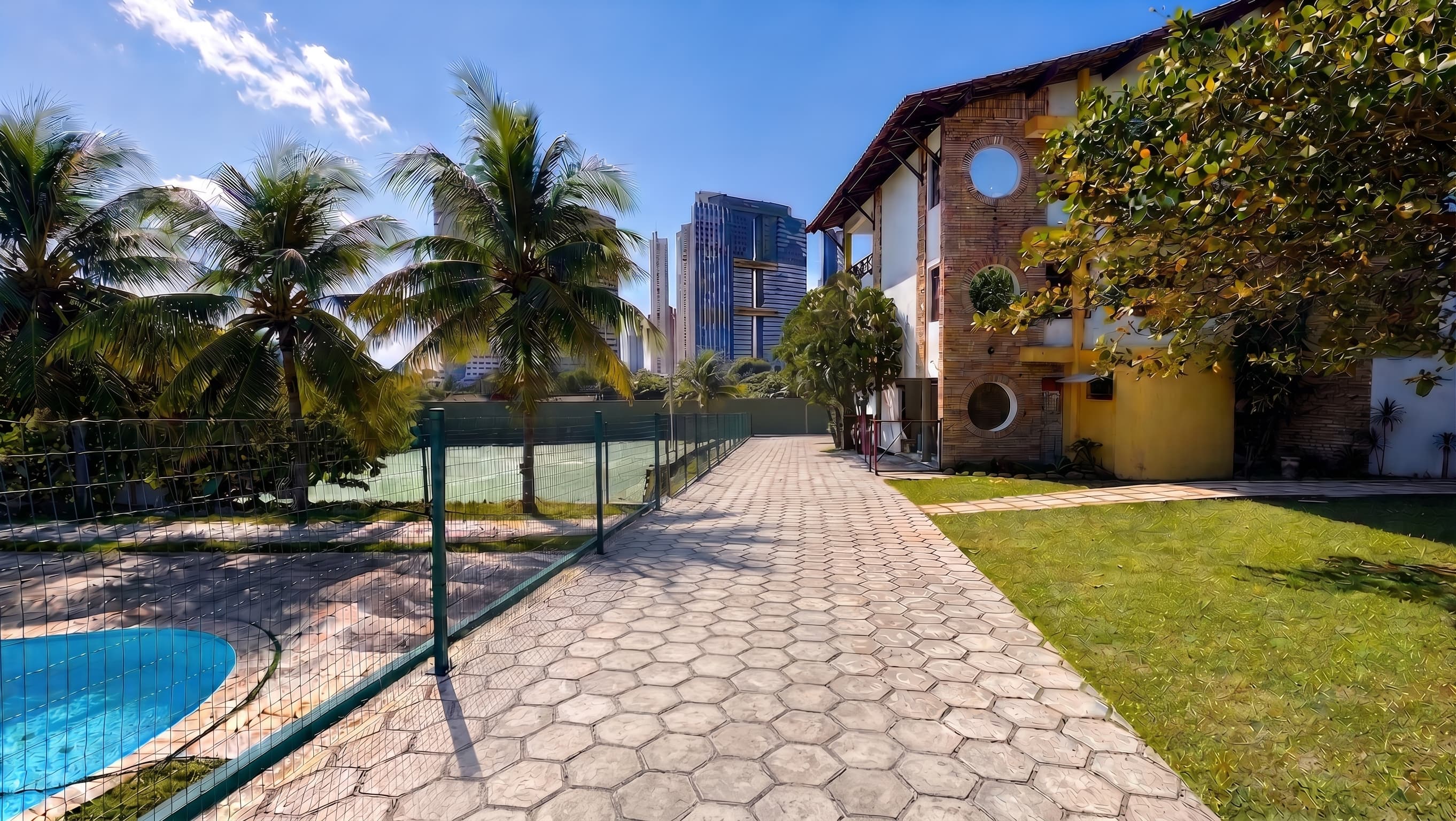 A casa da Mansão Pet, com gramado, piscina e coqueiros